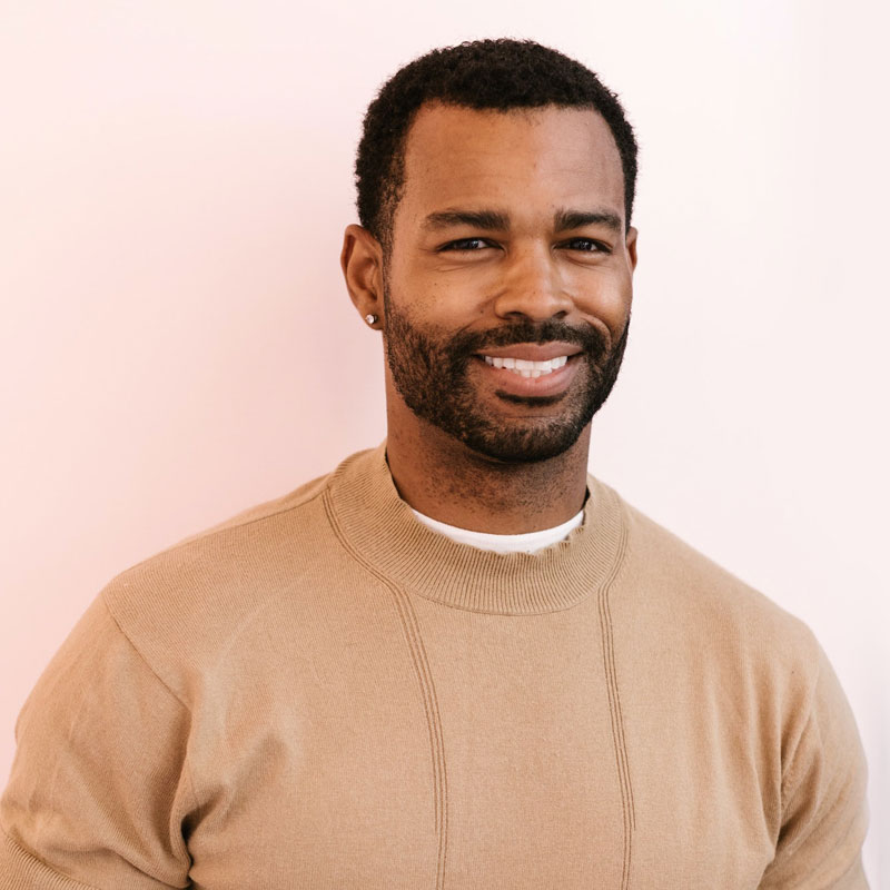 photo of smiling man in a tan sweater