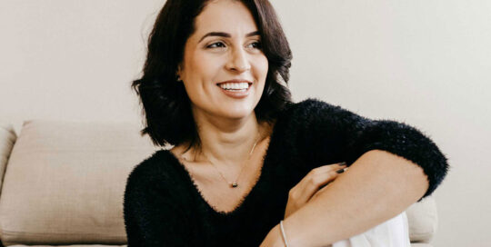 Woman on a couch who received hormone pellet therapy in the Atlanta area.